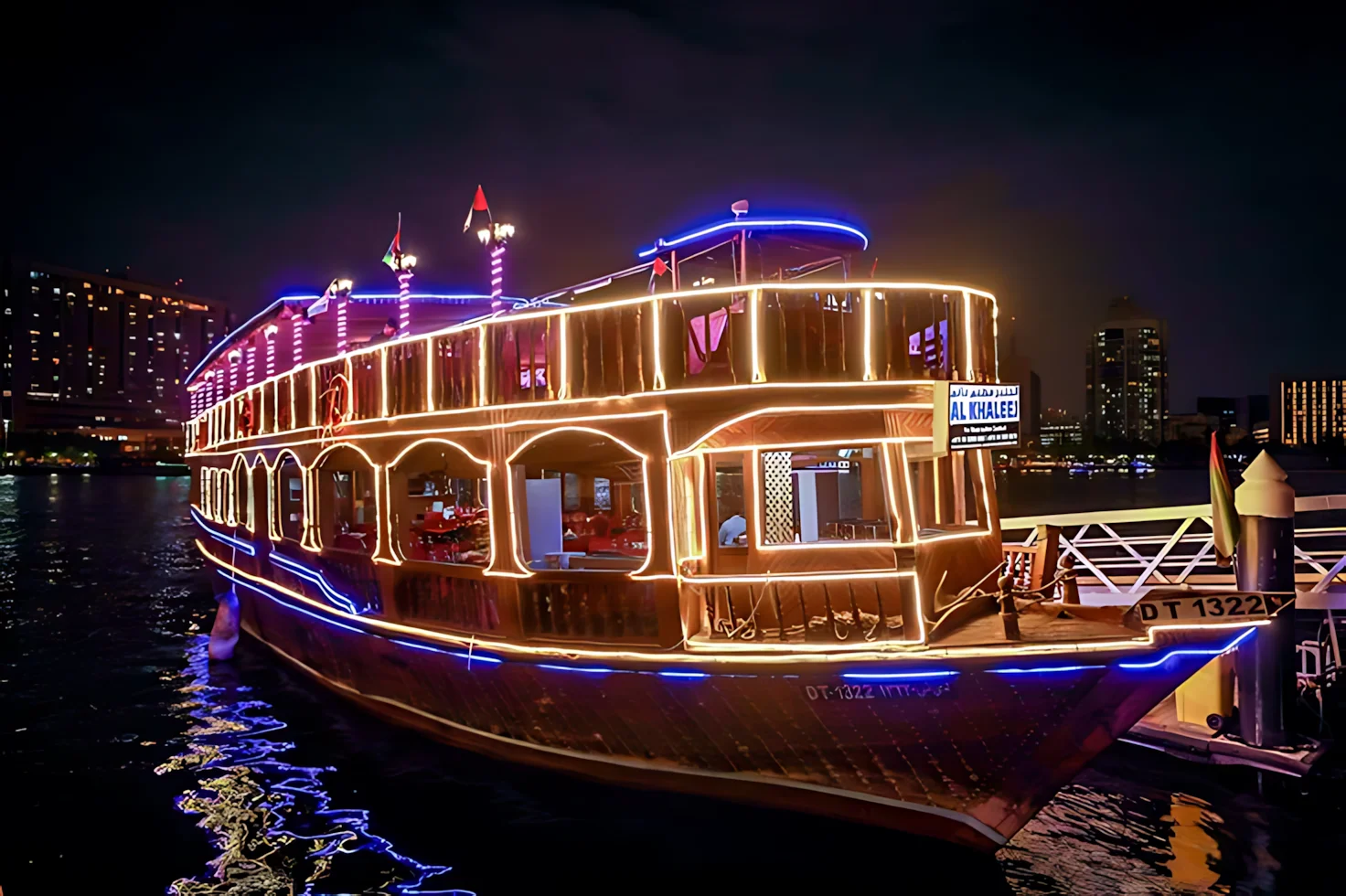 Traditional dhow dinner cruise sailing along Dubai Creek at night