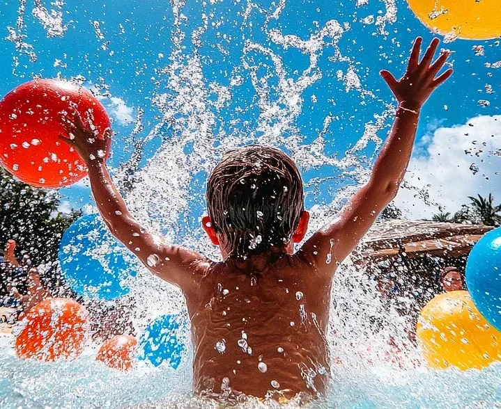 Child splashing in a family play area at a Dubai waterpark