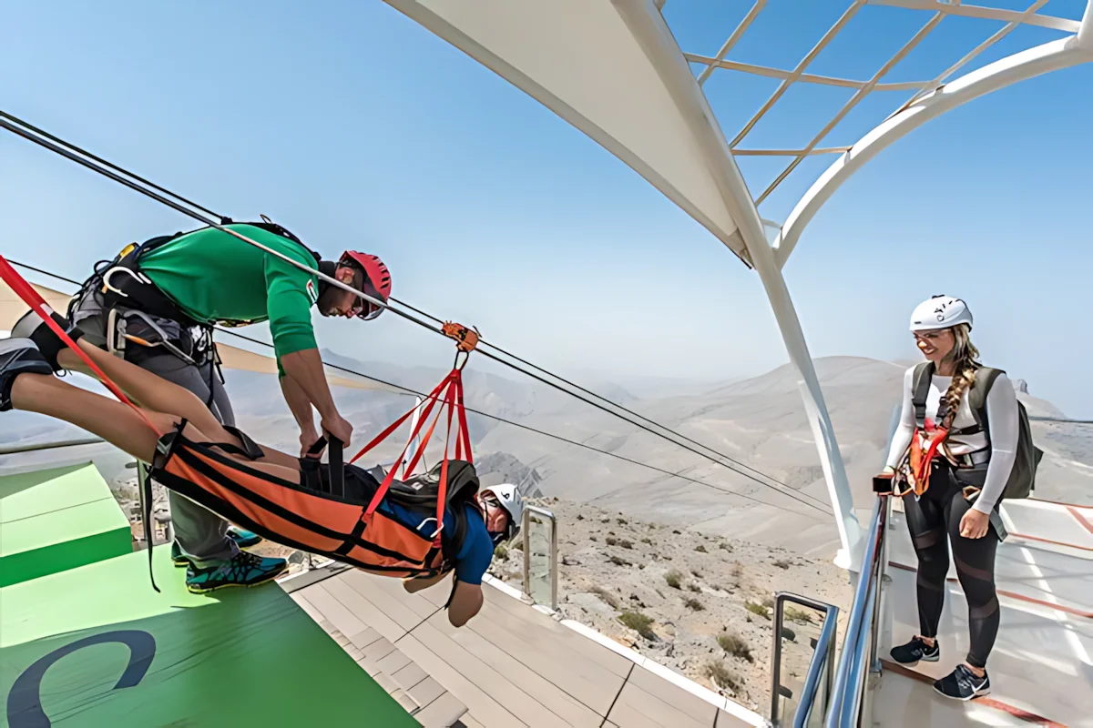 Traveler preparing for the Jebel Jais zipline adventure in the Hajar Mountains