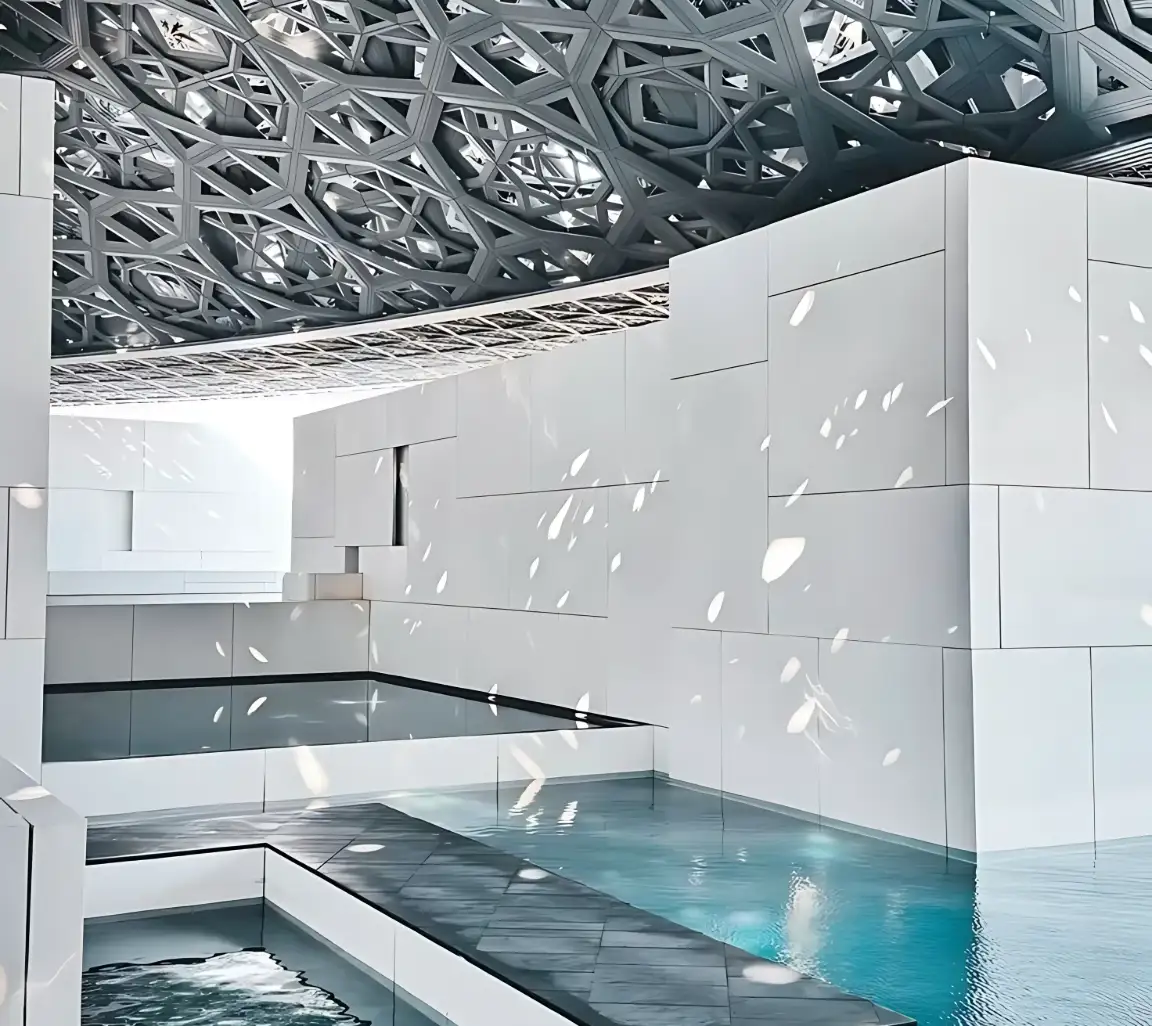 Geometric dome of Louvre Abu Dhabi reflected over the surrounding water